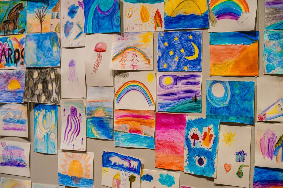 DIY magnetic grid wall for art display for kids showing colorful 3d paper animals mounted with small magnets